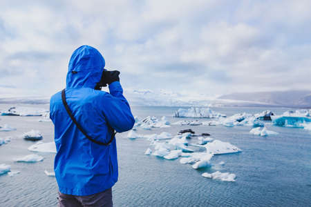 nature travel photographer, person taking photo of arctic icebergs in Icelandの写真素材