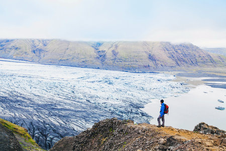 traveler enjoying panoramic view of glacier in Icelandの写真素材