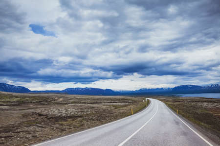 travel background, beautiful asphalt road in dramatic landscape of Icelandの写真素材
