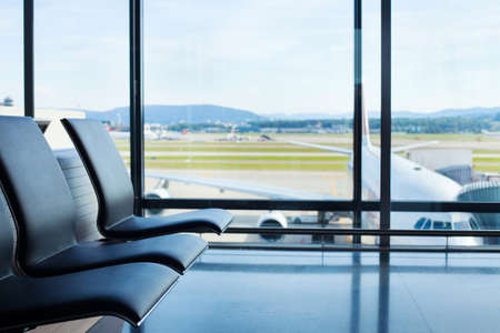 airport background, chairs in waiting lounge and airplane in the window, interiorの写真素材