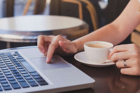 checking email in cafe with cup of coffeeの写真素材