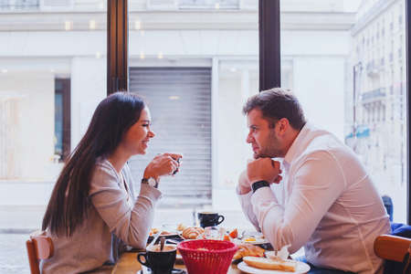 eating in restaurant, happy smiling couple having lunch in cafe, datingの写真素材