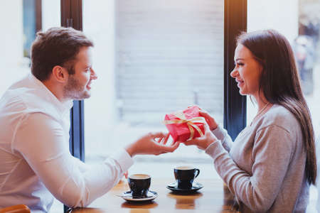 gift for valentines day, birthday or anniversary, man and woman in cafe, couple portraitの写真素材