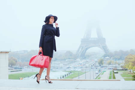 happy smiling woman shopping in Paris, young caucasian girl  tourist with bag near Eiffel towerの写真素材