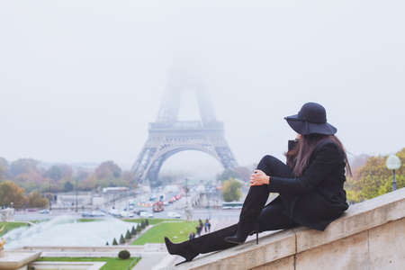 autumn and winter in Paris, fashion woman looking at Eiffel Tower in foggy day, Franceの写真素材