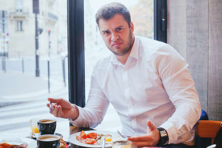 displeased angry customer in restaurant, man unhappy with food and bad serviceの写真素材