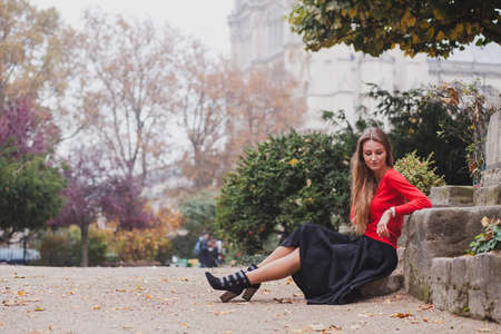 beautiful woman in red, portrait of caucasian fashion young model with long hair sitting alone, psychology conceptの写真素材