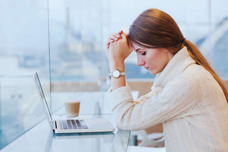 information overload, stress concept, sad desperate woman in front of computerの写真素材
