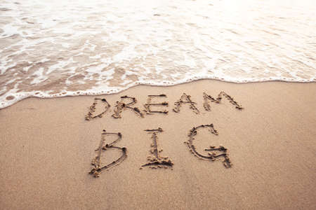Dream big, motivational sign on the sand of beachの写真素材