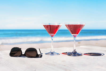 Summer holidays concept, two cocktails and sunglasses on the beach table, tropical vacationsの写真素材