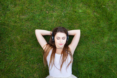 enjoy the music, top view of young woman in headphones, backgroundの写真素材