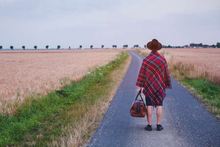 leaving home, traveler walking on the road, summer trip, journey or travel backgroundの写真素材