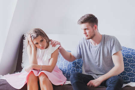 compassion or apologize, psychological support in difficult situation, young family, sad depressed woman and man trying to helpの写真素材