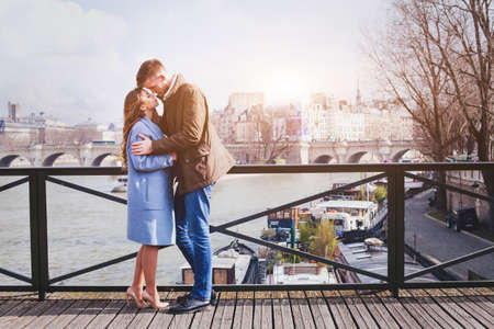 romantic date, young couple kissing on the bridge in Parisの写真素材