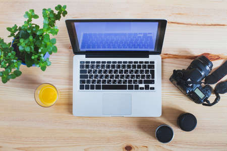 workplace of photographer, top view of gear, camera with lenses and laptop computerの写真素材