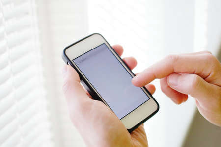 closeup of hands with smart phone, mobile application, empty screenの写真素材