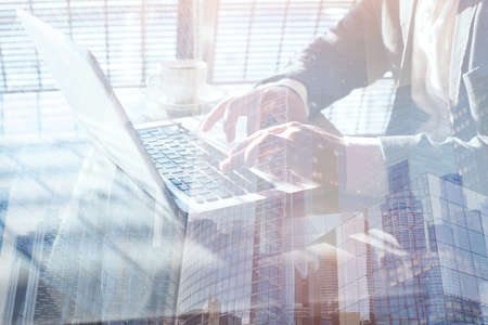 working on laptop computer, double exposure, close up of hands of business manの写真素材