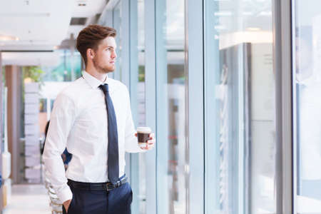 businessman looking at the window in the office and thinkingの写真素材