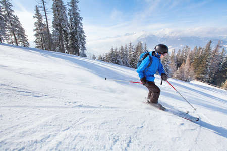 downhill skiing, skier going fast down the mountain, winter sport backgroundの写真素材