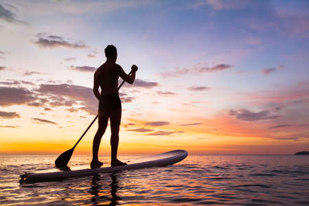 paddleboard on the beach at sunset, paddle standing in Thailandの写真素材