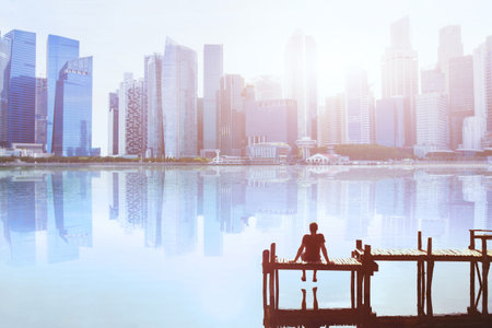 dream concept, man sitting on the pier and enjoying modern cityscape skyline viewの写真素材