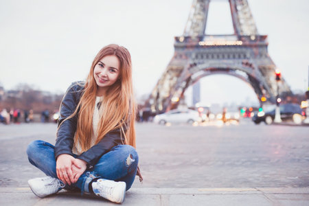 smiling happy beautiful woman tourist in Paris looking at camera, portrait of caucasian girl near Eiffel Towerの写真素材