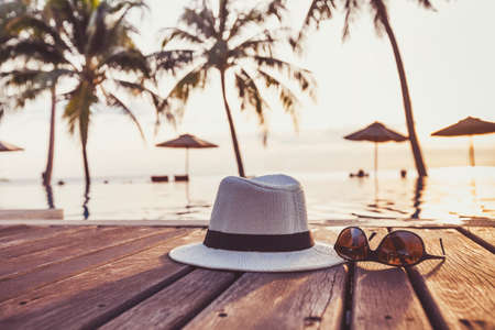 travel and tourism concept, sunglasses and hat near tropical swimming pool, beach holidaysの写真素材
