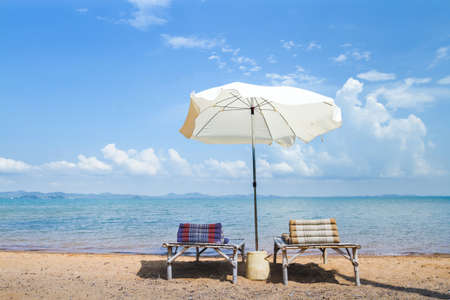 beach holidays, two deck chairs and umbrella near the sea, summer relaxation conceptの写真素材