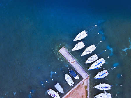 aerial view of boats parked near pier on the lake, blue water landscape from droneの写真素材