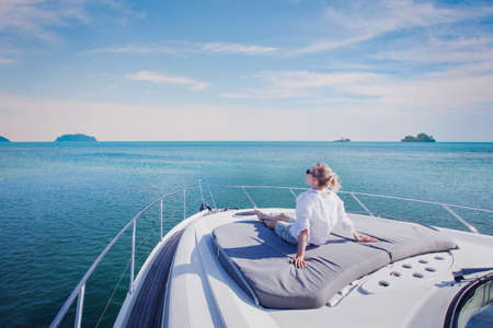 beautiful woman enjoying luxurious yacht cruise, sea travel by luxury boatの写真素材