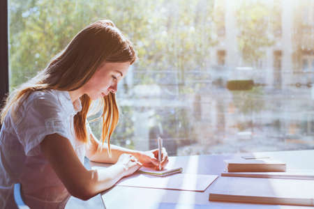 education, student girl in university during exam, young woman studying, people writing testの写真素材