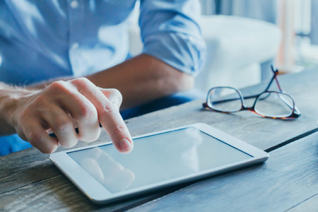 man reading emails and news on social media, close up of hands using digital tablet computer,...