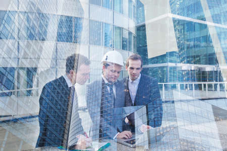 real estate project management team meeting, construction work of modern building, double exposureの写真素材