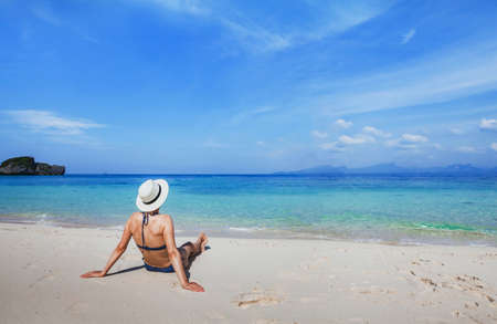Vacation on paradise white sand beach, tropical holidays travel,  woman tourist  relaxing near turquoise sea.の写真素材