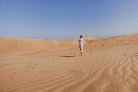 woman tourist running in sand dunesの写真素材