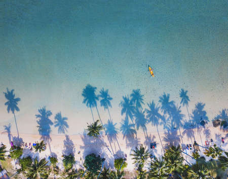 paradise beach with kayak, aerial landscape of beautiful tropical sea and palm trees, top down view from droneの写真素材