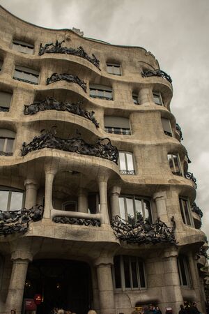 BARCELONA, SPAIN - APRIL 27, 2017: futuristic building by architect Antoni Gaudi casa mila with stained glass mirrors during rainのeditorial素材