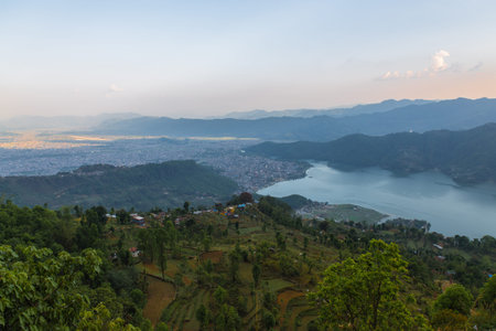 mountains silhouette and phewa lake view from sarangkot hill in the sunset time with road in Nepal
