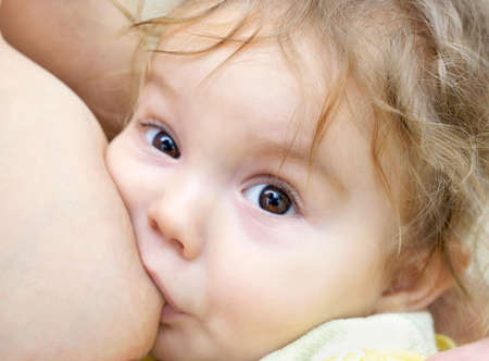 Nine month old baby-boy with brown eyes nursing の写真素材