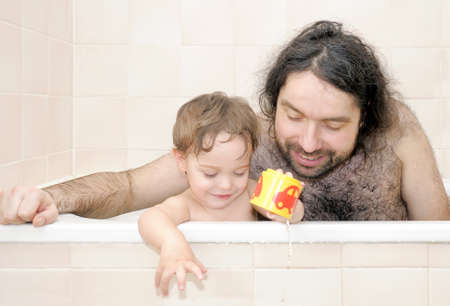 Father bathing together with his half-year-old baby-boyの写真素材