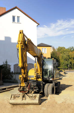 Middle size yellow excavator on the construction site in the historical part of Jena, Thuringia, Germanyの写真素材