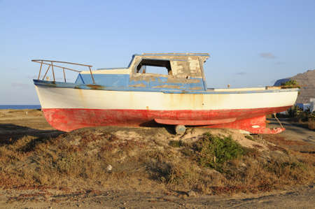 An old fishermen boat abandoned on shore; Graciosa island North from Lanzarote, Canary islands, Spainの写真素材