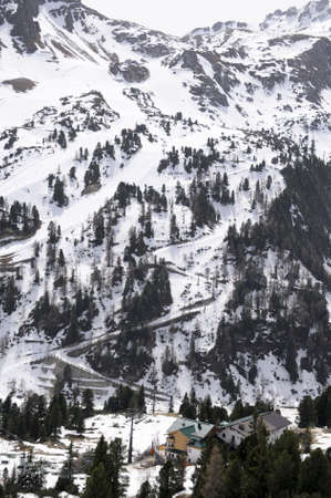 Mountain slope under snow with a foot path, ski lifts and a hotel in Austrian Alpsの写真素材