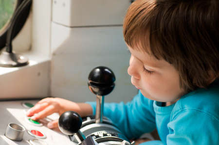 Little boy presses green button in cabine of Berlin UBahn trainの写真素材