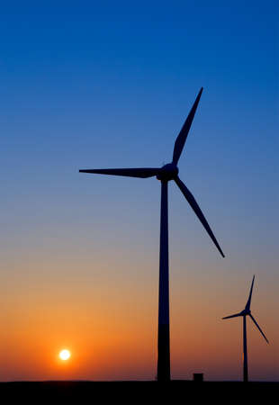Silouettes of modern windmills against setting Sunの写真素材