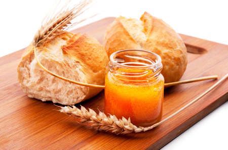 Freshly baked bread rolls, wheat ears and honeyの写真素材