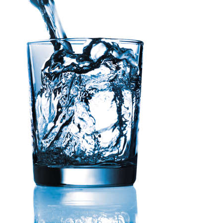 pouring splashing water in a reflective glassの写真素材