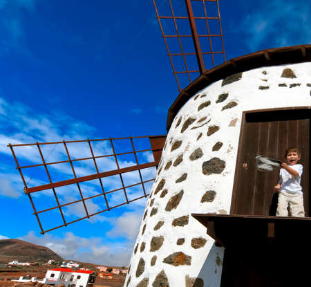 little boy by traditional windmill, Fuerteventura, Canary islands, Spainの写真素材