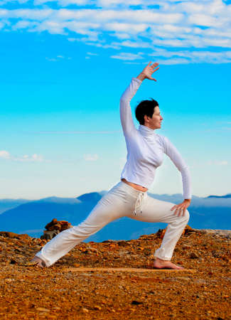 Young woman practicing yoga in front of a mountain の写真素材