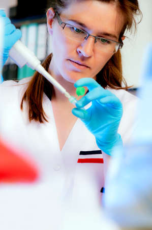 Portrait of a scientist with an automatic liquid dispenser in modern laboratory, shallow DOFの写真素材